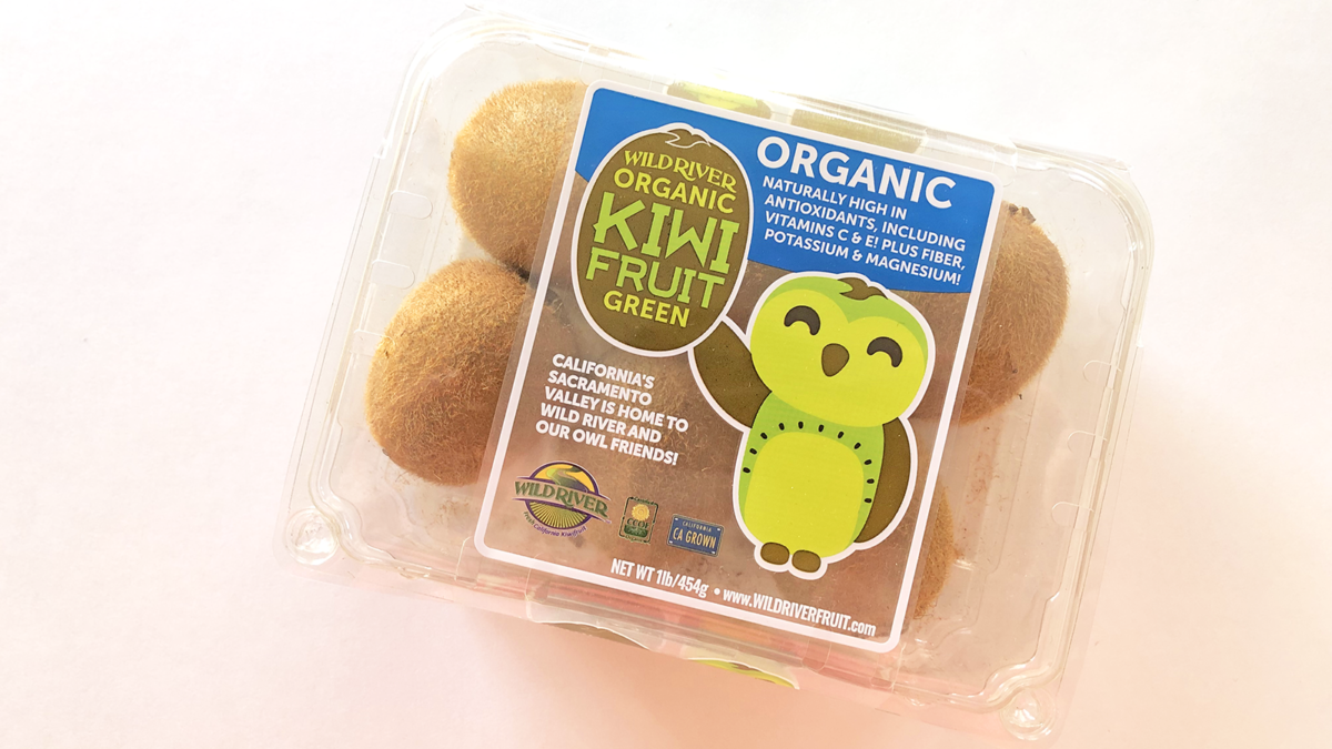 Our Owl Friends and associated kiwi owl logos are trademarks of Wild River Marketing Inc. Designed by Ben Young Landis and Guy Rogers. The photo shows a plastic clamshell container with six kiwifruits inside. The container's graphic shows the smiling Wild River green kiwi owl with one wing waving. Graphic says "California's Sacramento Valley is home to Wild River and Our Owl Friends!" and that the fruits are organic, naturally high in antioxidants, including vitamins C & E! Plus fiber, potassium & magnesium!