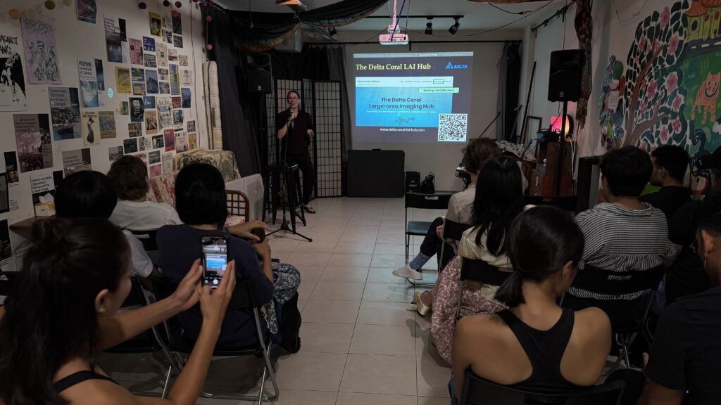 Photo of Professor Crystal McRae with slide and Q R code for the Coral L A I Hub, with audience holding their smart phone up to snap the code.