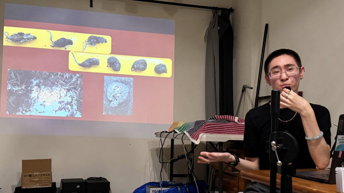 River Basham speaking in front of a slide with mice crypts created by burying beetles